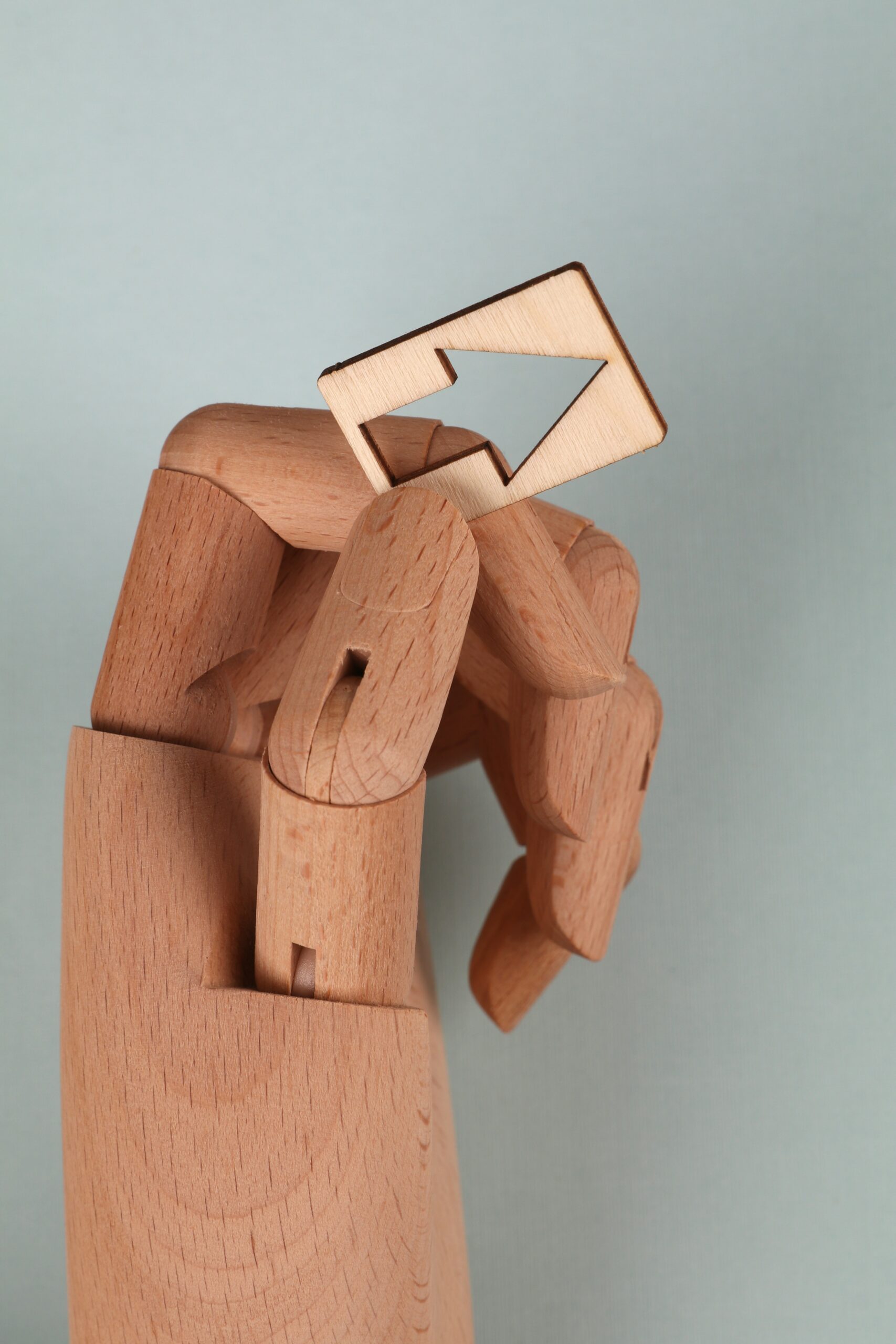 wood model robotic hand with cut out arrow