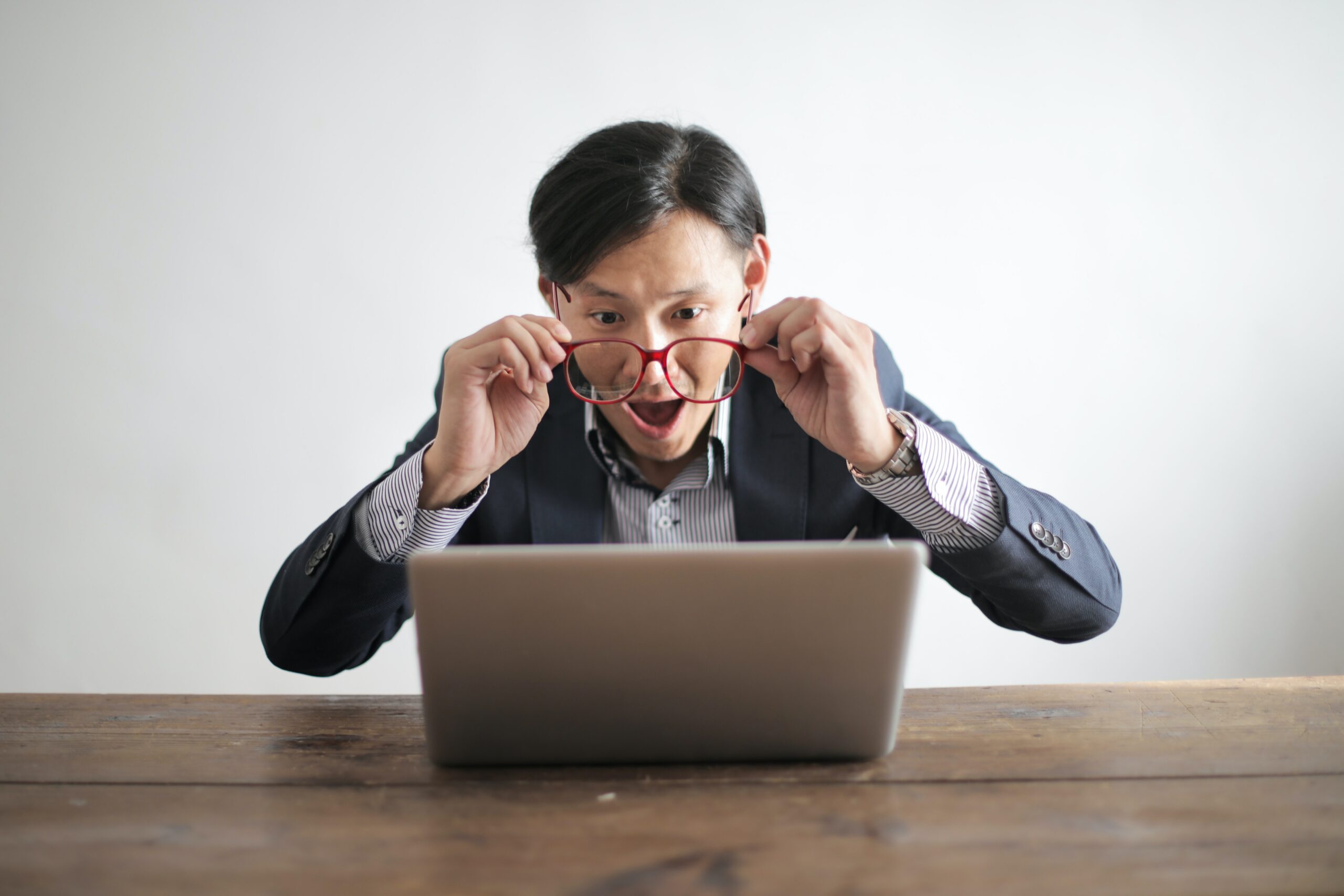 person with glasses looking at laptop