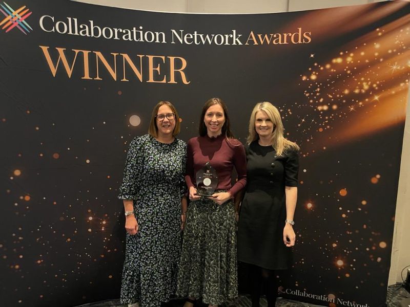 Anna Roughly, Head of Insight at the Lending Standards Board collecting the award with two female colleagues.