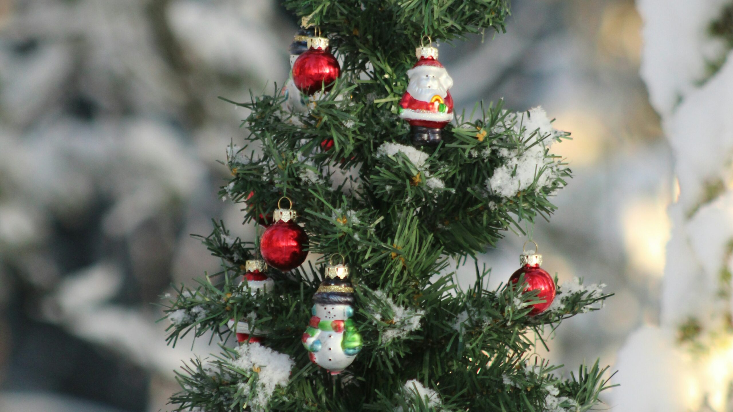 tiny Christmas tree with ornaments in the snow